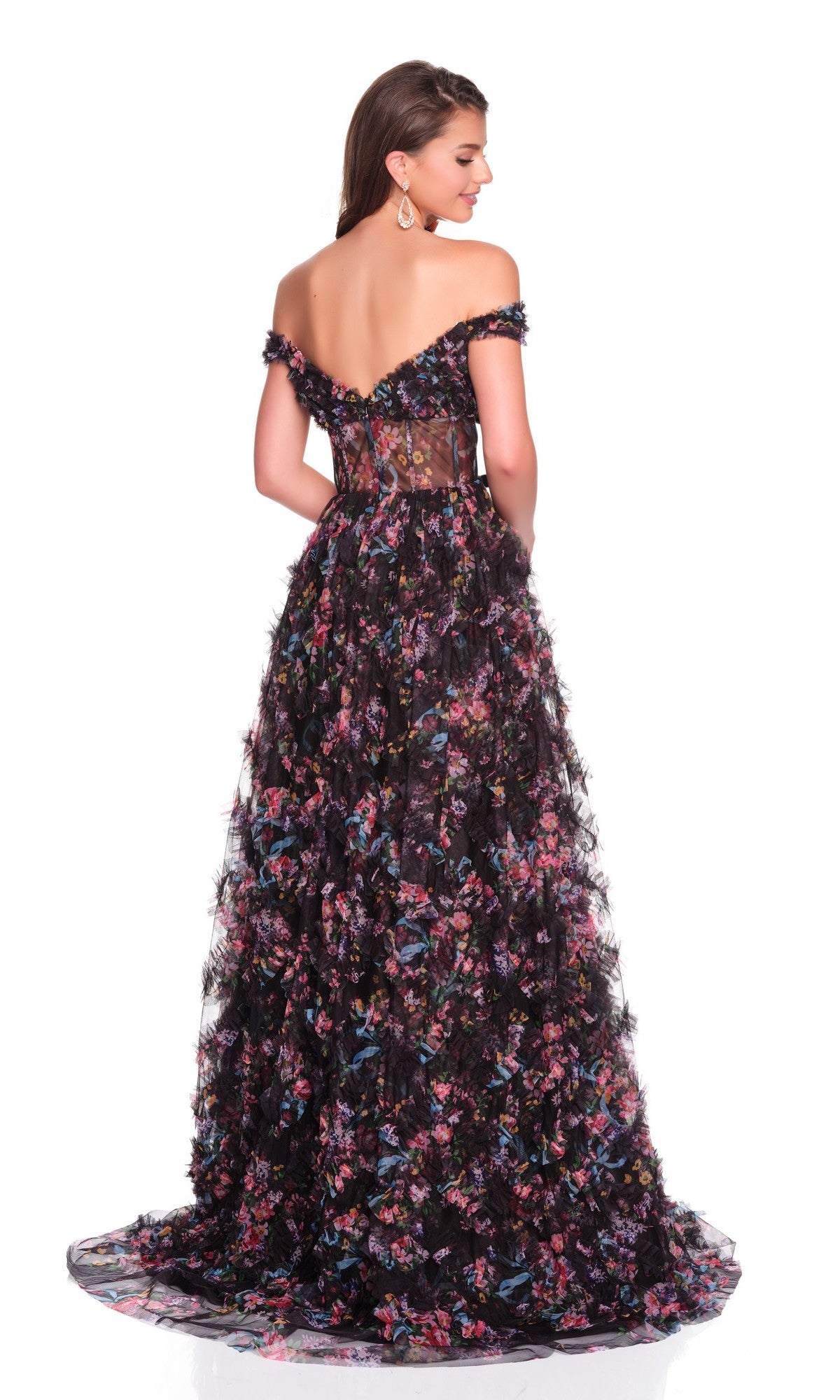 A woman poses against a white background, wearing the Dave and Johnny 12508 long prom dress—black, off-the-shoulder with colorful floral patterns, a sweetheart neckline, and a sheer lace back panel.